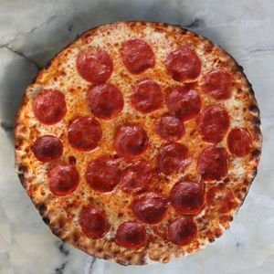 Tasty pepperoni pizza with melted cheese on a marble background.